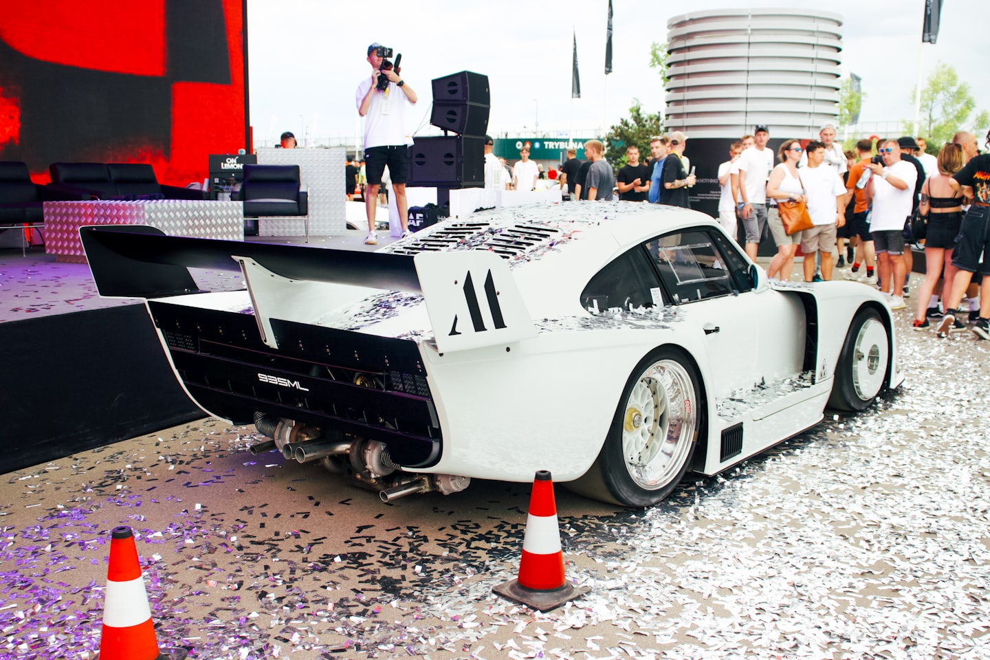 White custom sports car covered in confetti at an event.